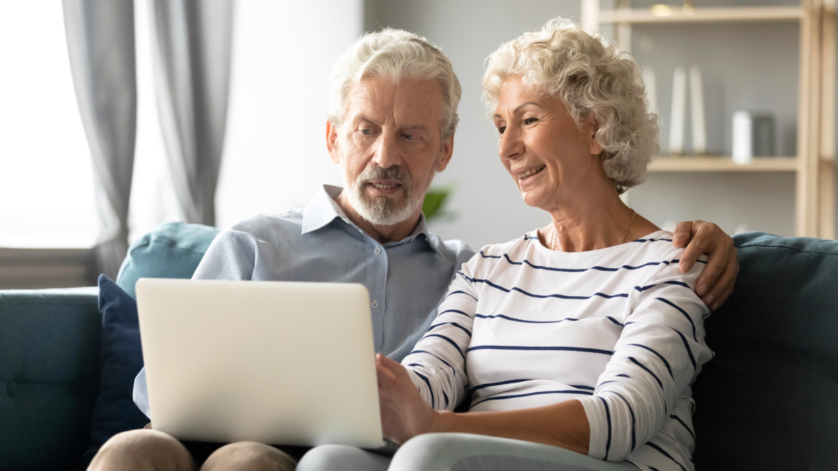Retirement planning couple reviewing finances online before asking key questions about savings, goals, and security.