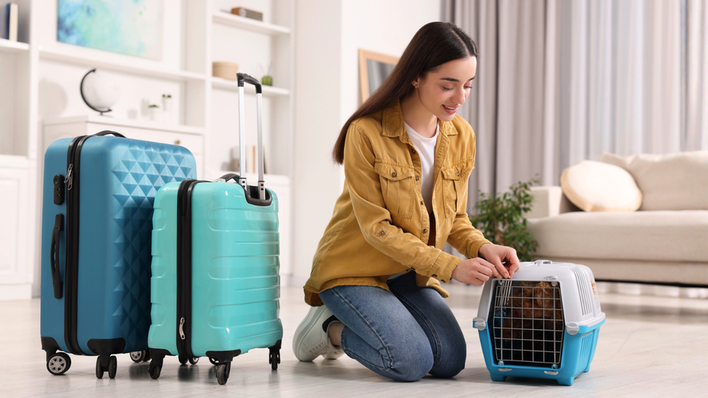 Pet owner preparing carrier and luggage for stress-free move with pets during relocation planning safely.
