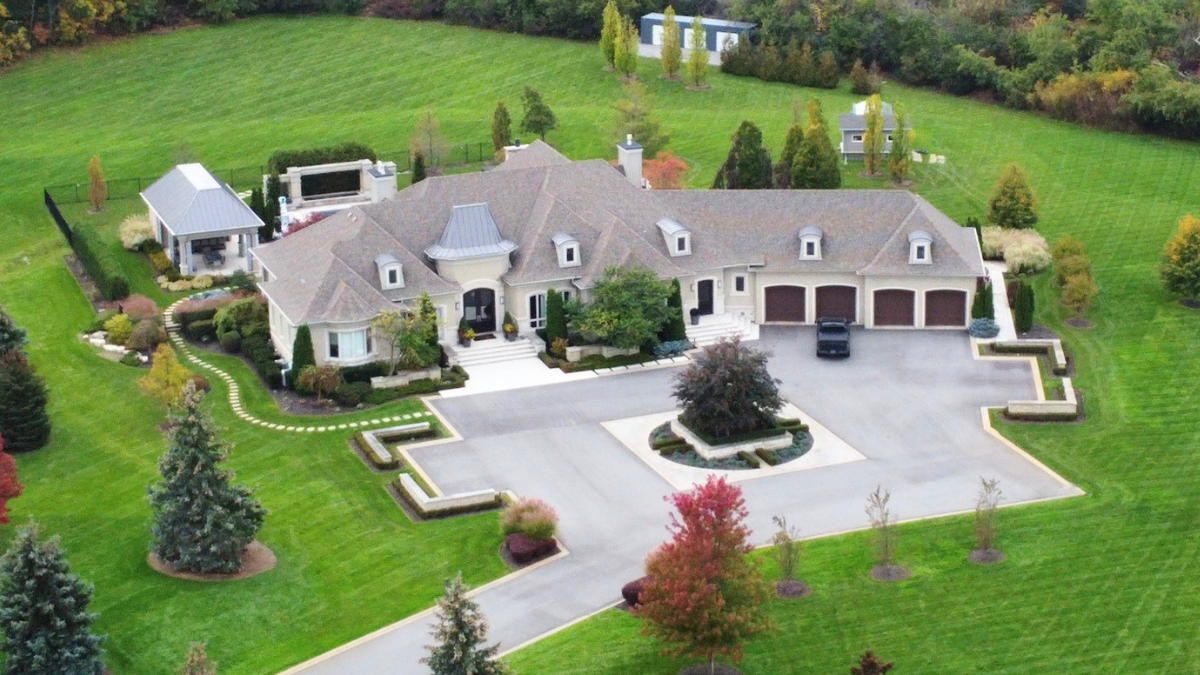 Aerial estate property with manicured grounds shows small maintenance habits protecting massive real estate assets.