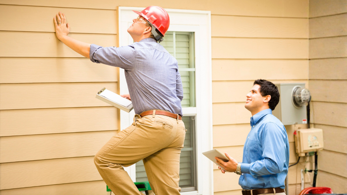 Inspector assessing property siding condition before investor adds rental unit to investment portfolio carefully decisions.