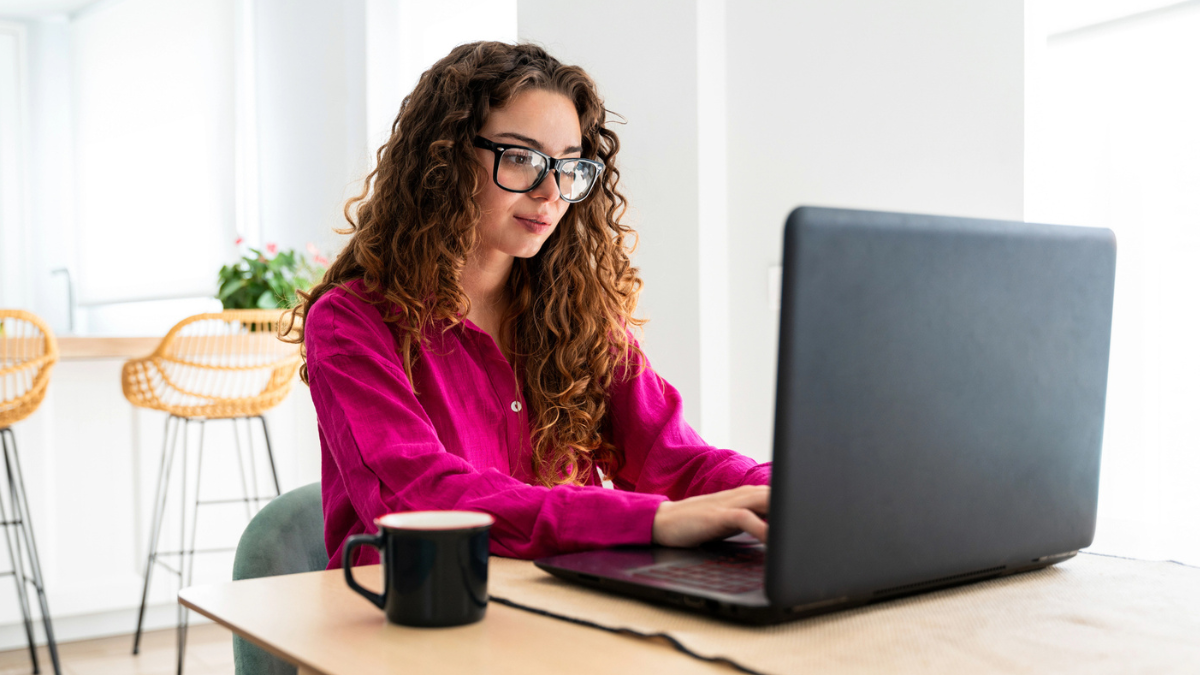 Professional designer creating a real estate pitch deck presentation on a laptop from a home office.