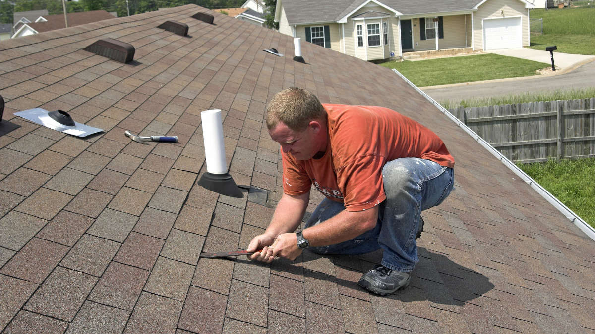 Roofer performing roof repair work on roof
