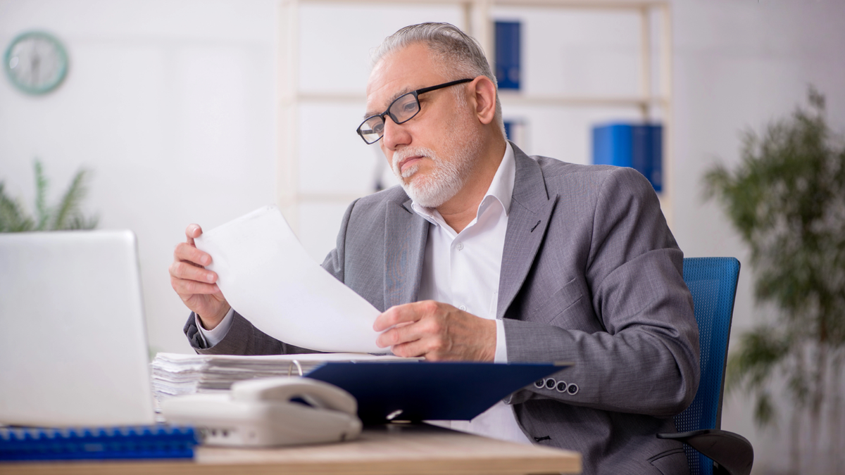Real estate professional reviewing contract documents before making amendments to property agreement terms and conditions.