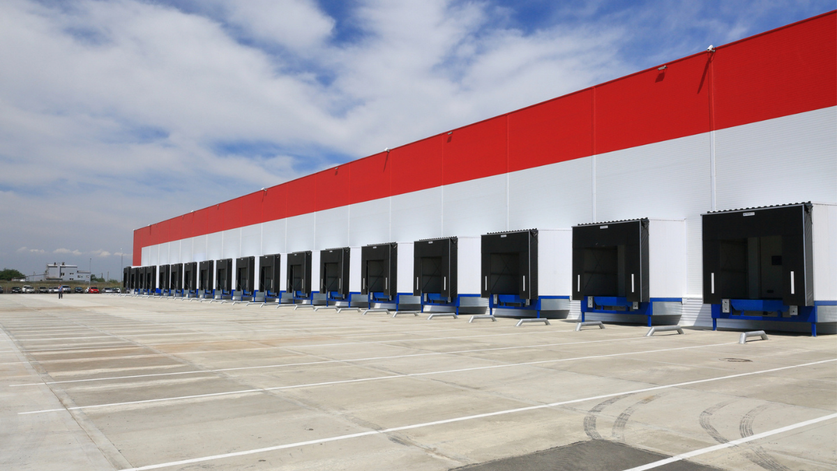 Commercial warehouse loading dock with maintained concrete pavement supports high-value property safety, durability, and operations.