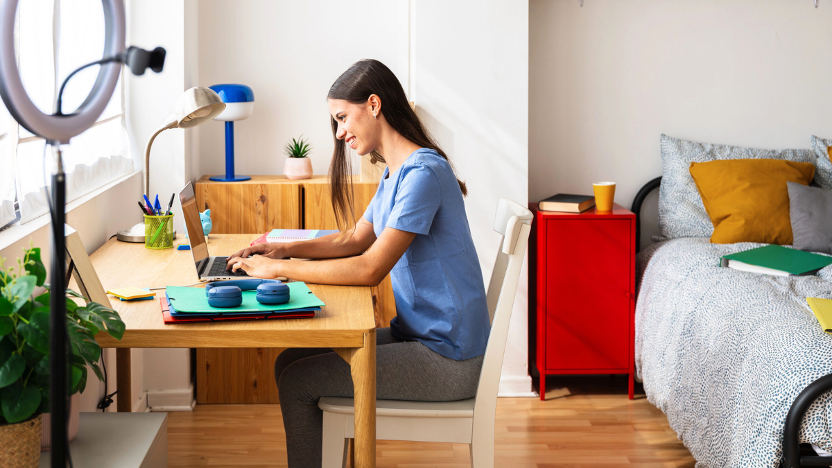 Student using laptop in Australian accommodation bedroom highlights comfortable study space for renters seeking housing.