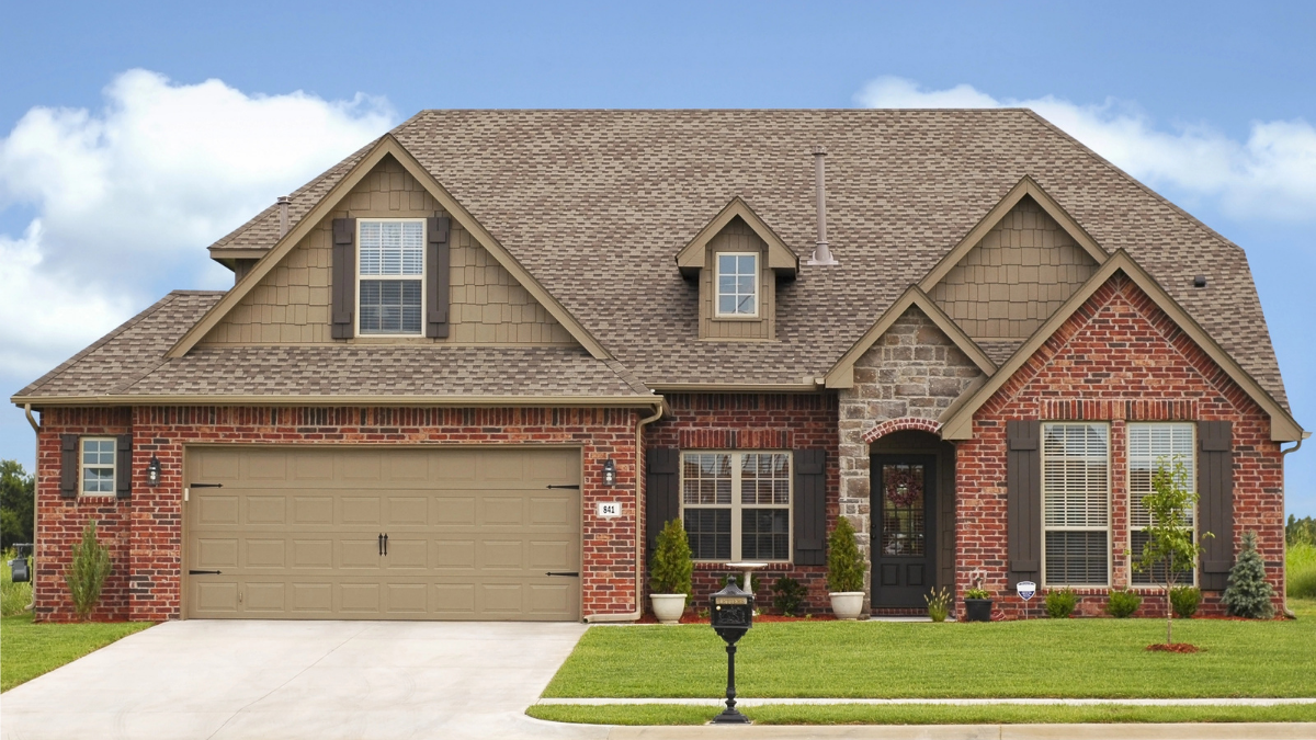 New roofing materials matched with existing brick home structure for cohesive curb appeal and durability.