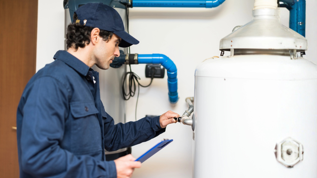 Technician inspecting a residential water heater during a home maintenance check.