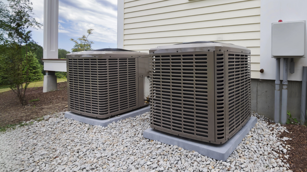 Two outdoor condenser units at a rental property.
