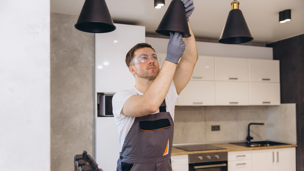Contractor installing durable lighting fixture shows low-maintenance rental property upgrades that improve appeal and efficiency.