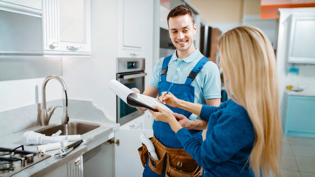 Home service technician reviews customer management paperwork with homeowner to improve communication, scheduling, and satisfaction.