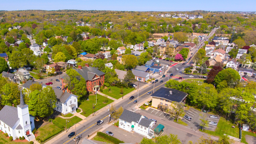 Aerial view of suburban real estate community highlighting team service milestones and property market growth.