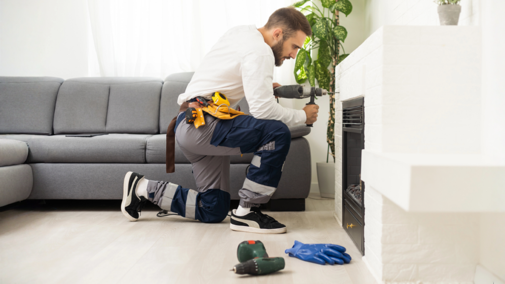 Maintenance technician repairing a rental property fireplace during routine preventive maintenance inspection.