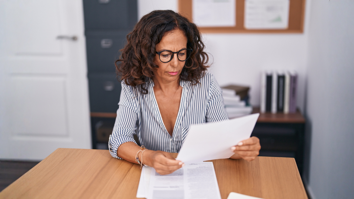 Divorced property owner reviewing quitclaim deed documents to safely transfer real estate ownership after divorce.
