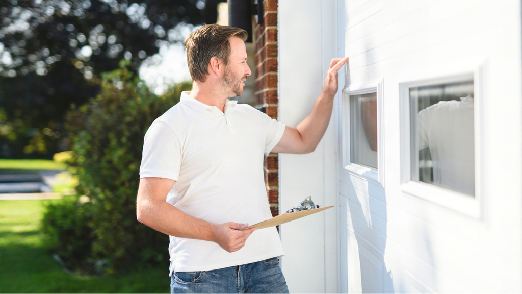 Landlord inspecting garage door during tenant turnover to identify safety issues and required maintenance checks.
