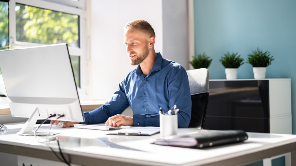 Architectural visualization professional working at a computer creating 3D design renderings in office.