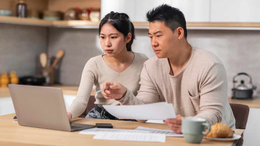 Couple reviewing rental property management expenses online to identify hidden costs and protect cash flow.
